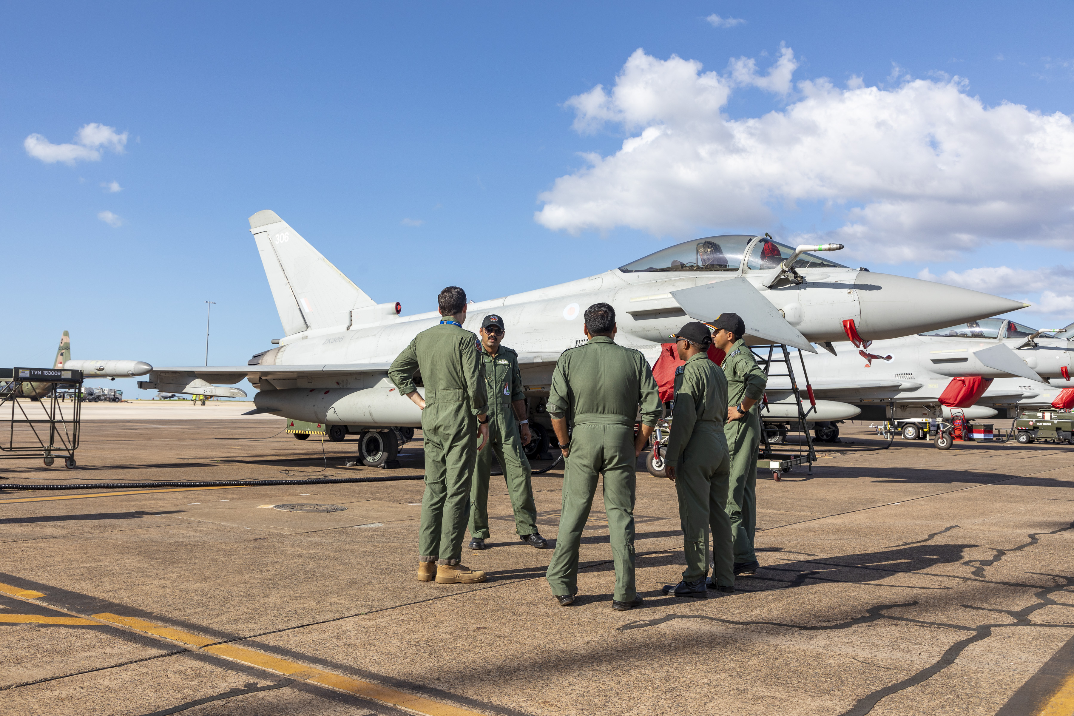 Image shows group of RAF aviators standing by Typhoons on an airfield.
